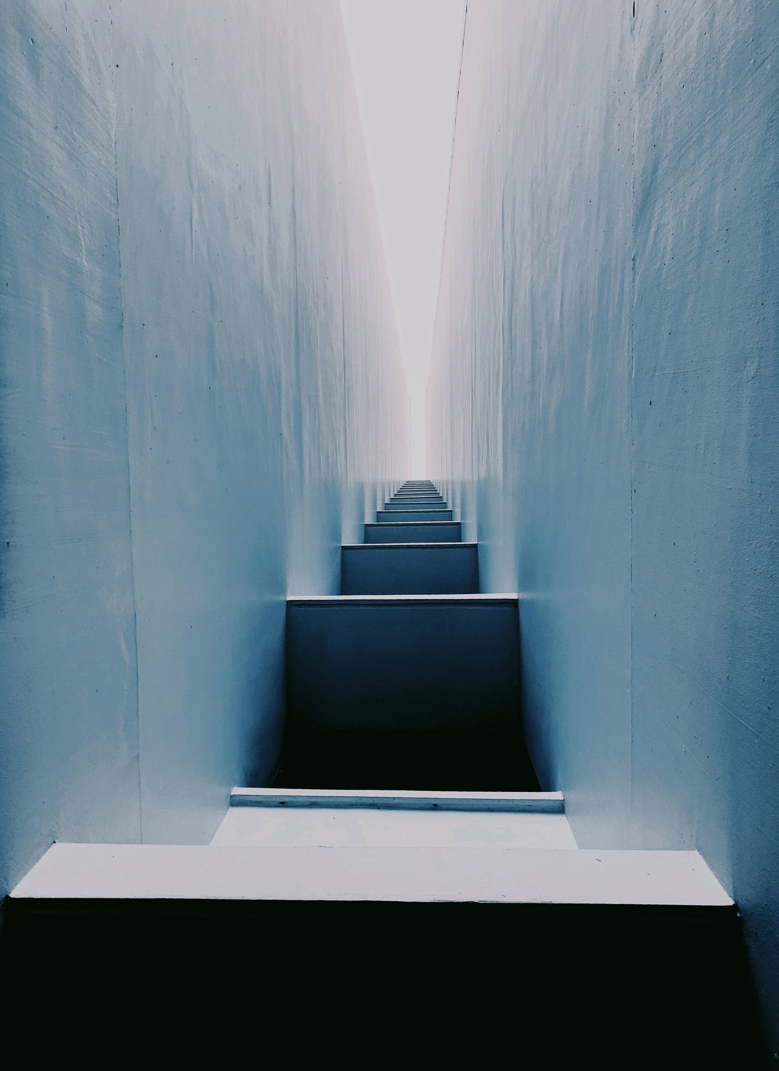 A blue-toned staircase leading towards light